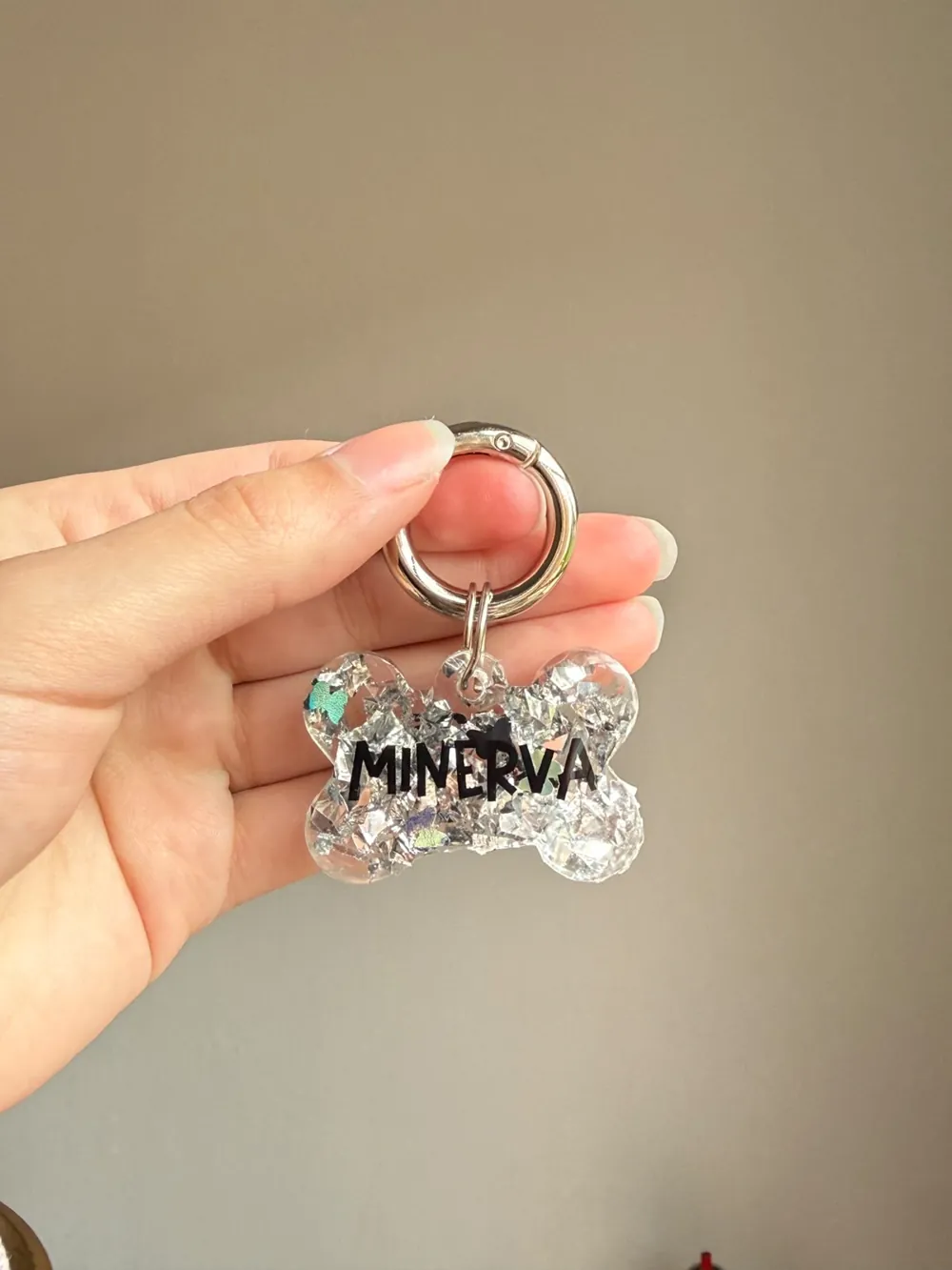 Chapita hueso glitter con el nombre Minerva